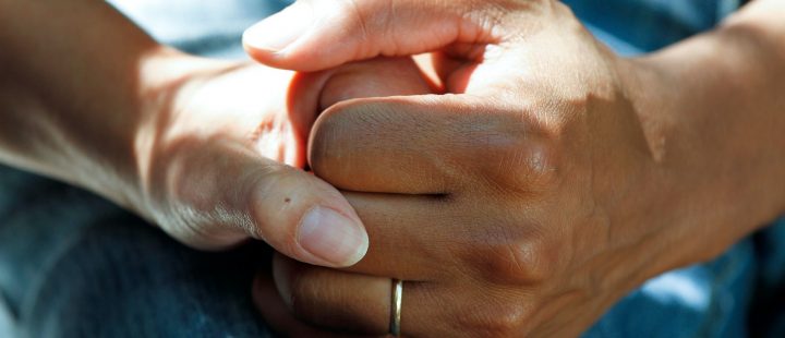 A health carer holding a patient's hand