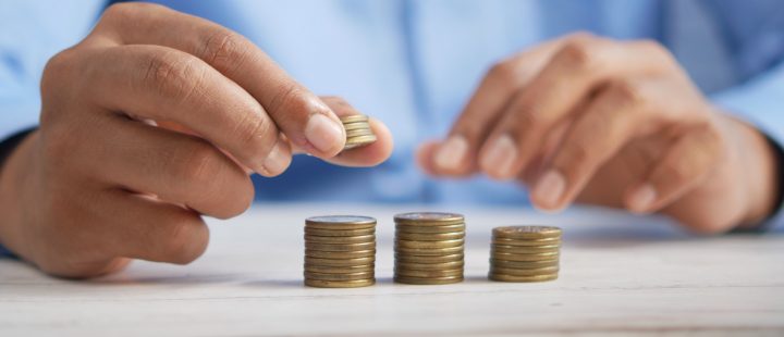 hands placing coins onto one of three piles